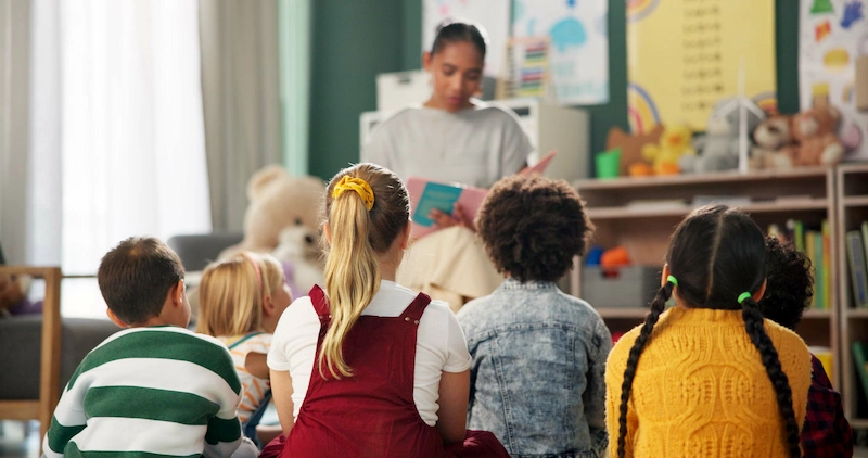 professora lendo historia para alunos em sala de aula