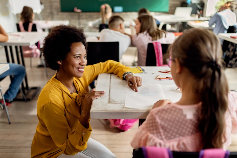 professora de ingles ajudando aluna em sala de aula