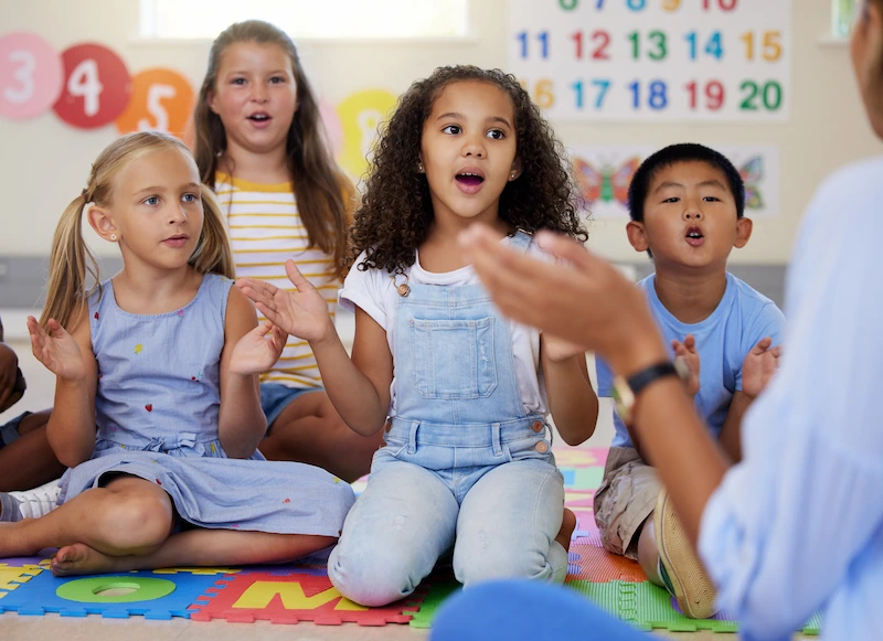 alunos em sala de aula cantando com a professora