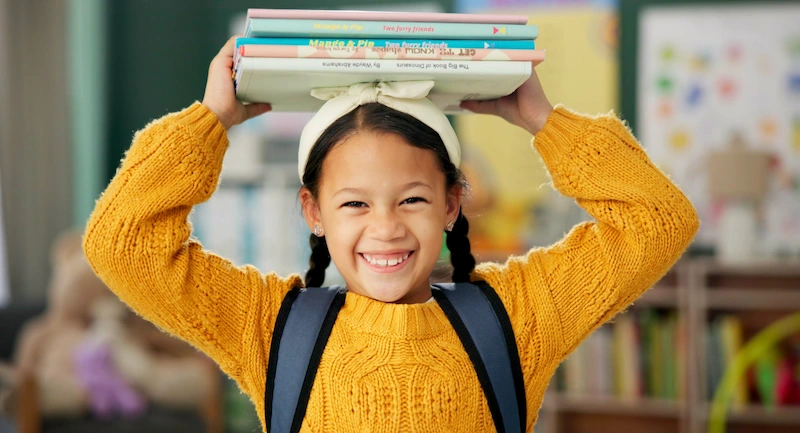 menina com livros sobre a cabeca