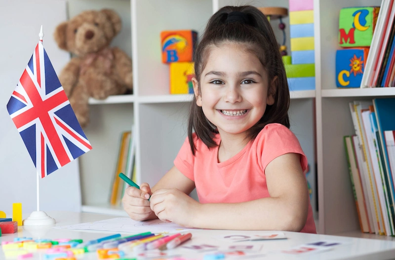 menina fazendo sua tarefa de ingles sorrindo