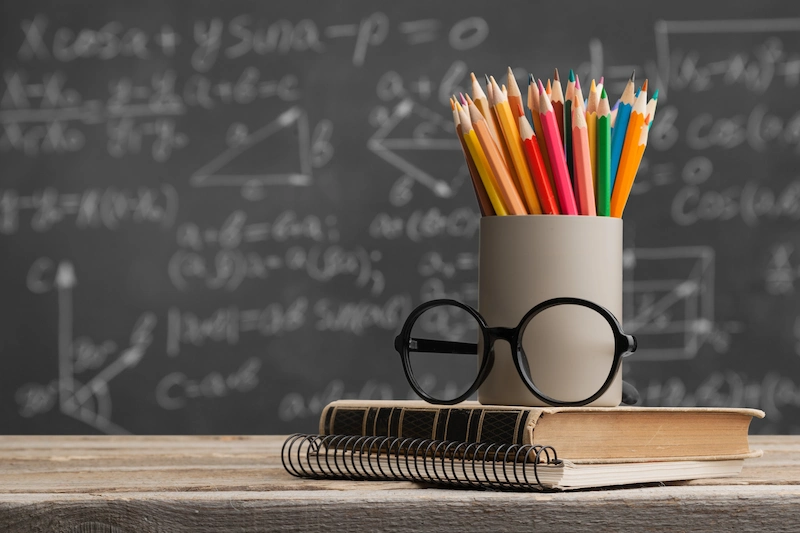 oculos e lapis de cor em cima da mesa na sala de aula