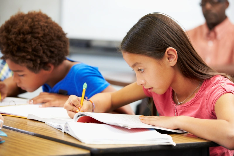 alunos focados em sala de aula escrevendo