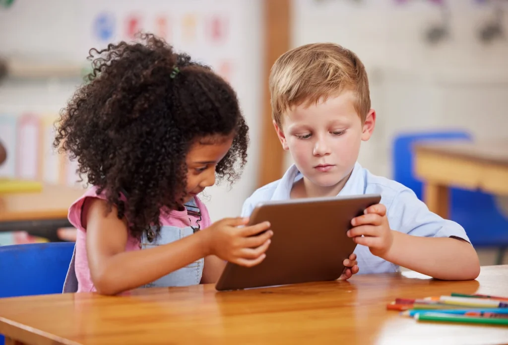 criancas usando um tablet na aula de ingles